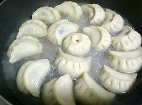 小火煎制3分钟，倒入清水，没过饺子三分之一，改成中小火，盖上锅盖，焖3分钟