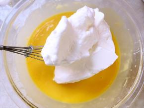 将打发好的蛋白分次加入到蛋黄糊中翻拌均匀