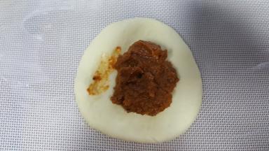 6．取其中一个面团压扁，中间放入馅料的1/3。