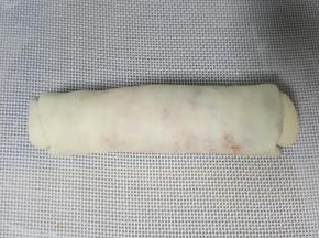 9．将擀长的椭圆形面皮，从上而下卷起。