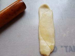 9．再取出一个面团，先用手轻微压扁，然后用擀面杖擀开。