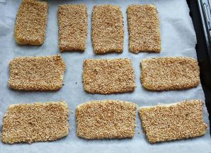 13．全部擀好后，上刷全蛋液，粘一层熟的白芝麻，放在铺有烘焙纸的烤盘上。