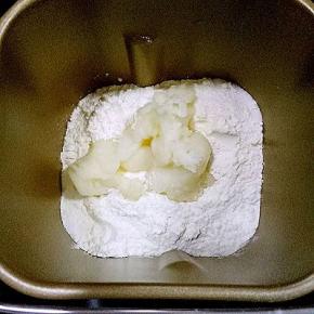 面包机内放入主面团除黄油外的用料，液体放下面，糖和盐对角放，中间放入酵母，放入汤种糊