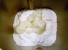 面包机内放入主面团除黄油外的用料，液体放下面，糖和盐对角放，中间放入酵母，放入汤种糊