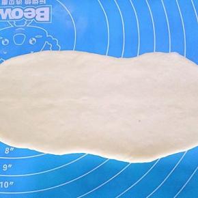 取一个面团擀成椭圆形（可以加上自己喜欢的馅料，肉松，豆沙，蜜豆都可以）