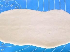 取一个面团擀成椭圆形（可以加上自己喜欢的馅料，肉松，豆沙，蜜豆都可以）