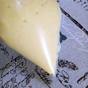 制作泡芙糊:水，色拉油，黄油一起煮开，迅速倒入高粉搅拌均匀，关火，等面糊晾凉，分三次加入鸡蛋液，做好的泡芙糊放入裱花袋备用，我用的是保鲜袋