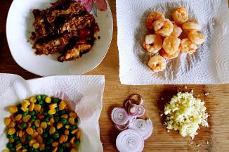 7．接下来准备我们所需的配料，将青豆与玉米粒煮熟，把表面的水用厨房纸擦干，黑虎虾仁汆烫熟，洋葱圈尽量切得细一点，我还加了昨天做的照烧鸡腿。当然这里的配料并不是固定的，可以按照你现有的和你喜欢的食物进行搭配。