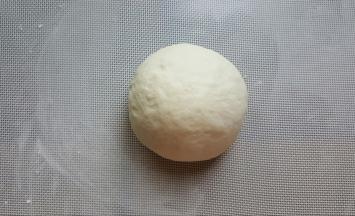 12．将面团取出，撒少许手粉，将面团揉圆。