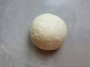 12．将面团取出，撒少许手粉，将面团揉圆。