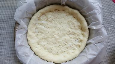 14．将披萨底移动到模具中，再次整理一下形状后，底部用叉子叉小孔。