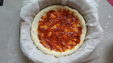 15．用勺子将酱料涂满披萨底。