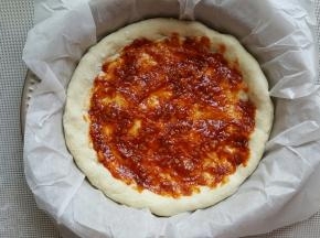 15．用勺子将酱料涂满披萨底。