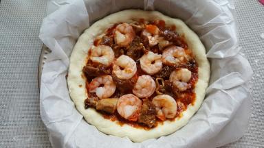 16．酱料的上面将黑虎虾仁和鸡腿肉摆满。