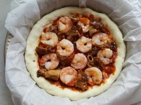 16．酱料的上面将黑虎虾仁和鸡腿肉摆满。