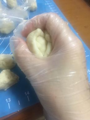 将油皮团捏扁，放入一个酥皮团，包好