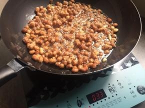 看着花生米，颜色已经微黄，偏深；温度调至500度，再炸一会，就差不多了；