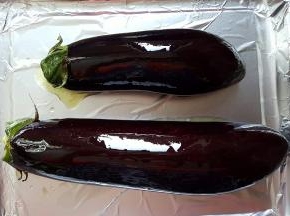 1.两根茄子洗净去蒂，用厨房纸将水分擦干，表面刷花生油，放入铺有锡纸的烤盘上。