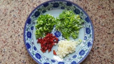 3.葱蒜青椒和干红辣椒切碎，放入一个大碗中加一大勺花生油，两勺生抽，加适量的食用盐。