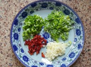 3.葱蒜青椒和干红辣椒切碎，放入一个大碗中加一大勺花生油，两勺生抽，加适量的食用盐。