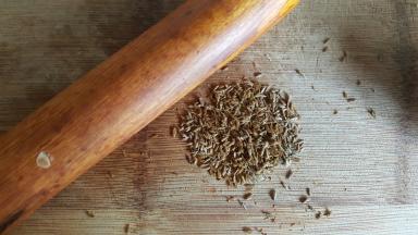 4.将孜然粒用擀面杖擀压。