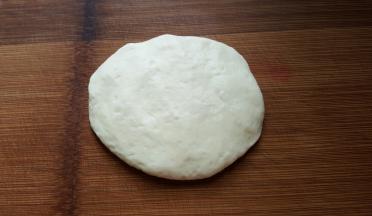 9．取出一个醒发好的面团压扁，把气排空。