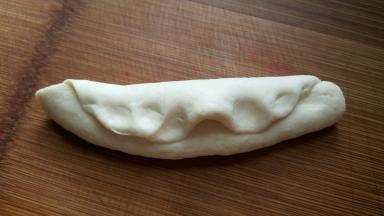 12．把面团翻过来，把剩下的一部分叠在上面。