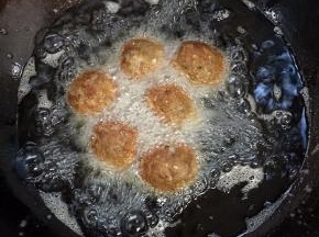 锅烧热倒入适量的油烧至七成热，放入团好的肉丸，中火慢慢的炸！