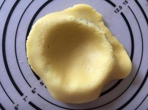 将面皮放入膜具中，去掉边缘多余的面皮
