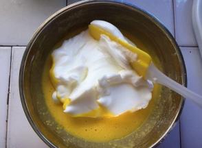 将三分之一的蛋白放入蛋黄中，用搅拌刀从下往上搅拌均匀