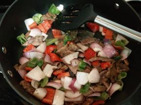 放入洋葱、青红椒块炒熟，加盐和鸡精调味即可。