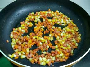 倒入玉米，胡萝卜和火腿翻炒至熟。