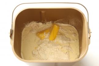 把食材一同放入面包桶，酵母和白砂糖对角放。