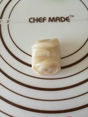 把醒好的酥皮中间按压，捏紧，擀成圆形