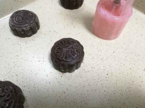 垂直按压在烤盘上，烤箱预热170度，入烤箱前在月饼表面喷些水，去掉表面的粉，去烤箱中层烤25分钟