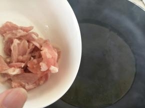 热锅冷油，油温六七成热时，加入腌好的肉片，中火炒一两分钟