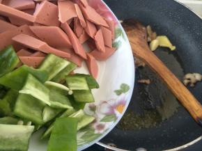 倒入切好的火腿和青椒，中火炒两分钟左右