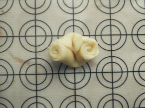 将饧好的面卷在中间用手掌立着压一下，两边朝中间推。