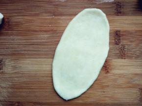 饧好的面卷再次压扁，擀成长条。