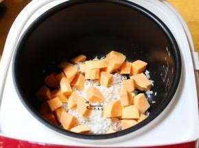 把大米、番薯块，一起倒入电饭锅内；