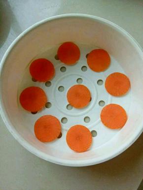 再把胡萝卜切片，放入蒸笼里。