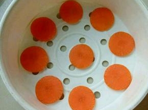 再把胡萝卜切片，放入蒸笼里。