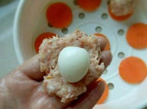 取一团肉泥压扁，放上鹌鹑蛋。