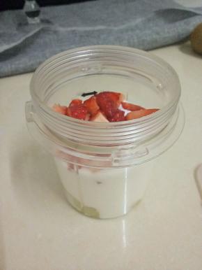 再把剩余的猕猴桃放入料理机中，加入酸奶和切成丁的草莓，打匀。