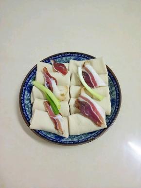 放上葱段和腊肉，再放入已开的蒸锅中，大火蒸个十分钟即可。