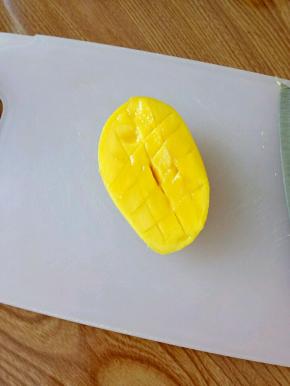 把芒果对半切开，用刀划十字