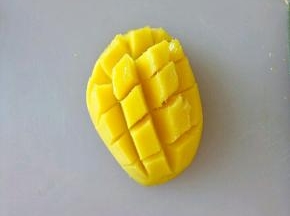 用手指朝上顶，用勺子把果肉剃下来。