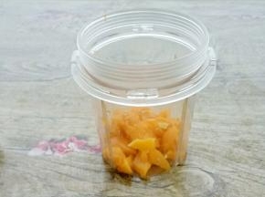 在把芒果肉放入料理机中。