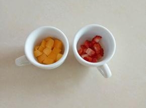 芒果和草莓切丁放入杯子底部，