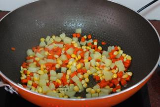 土豆下锅翻炒片刻，放入胡萝卜、玉米下锅爆炒八成熟熟；